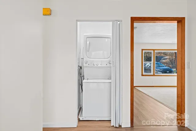 a view of a hallway with wooden floor and a cabinet