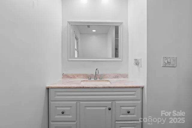 a bathroom with a sink vanity and a mirror