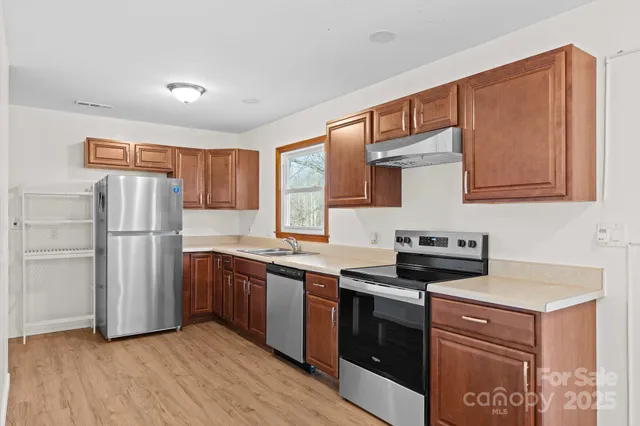 a kitchen with stainless steel appliances granite countertop a refrigerator stove and sink