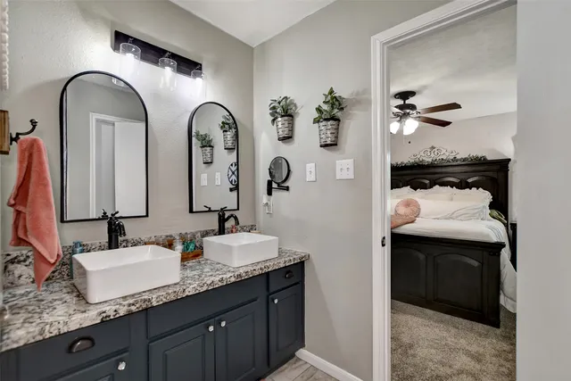 a bathroom with a granite countertop sink and a mirror