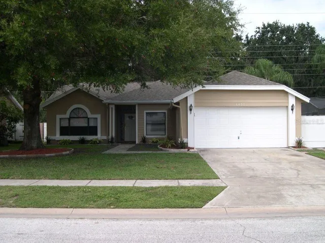 a front view of a house with a garden and trees