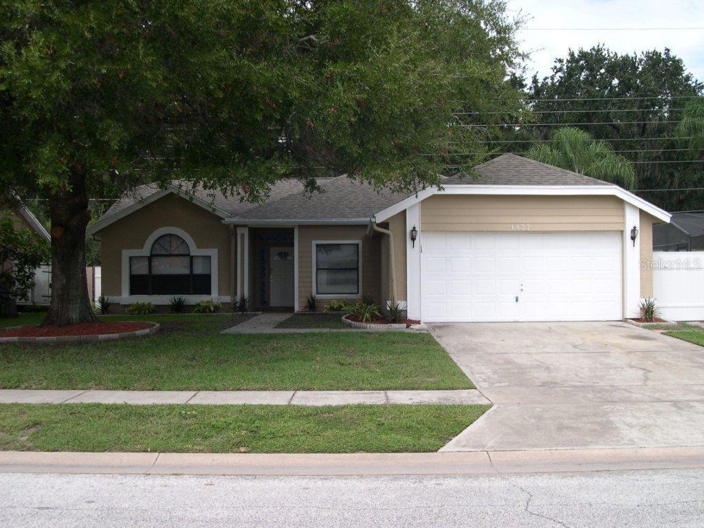 a front view of a house with a garden and trees