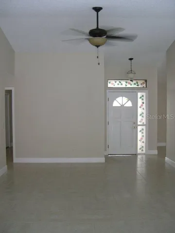a view of empty room with windows and ceiling fan