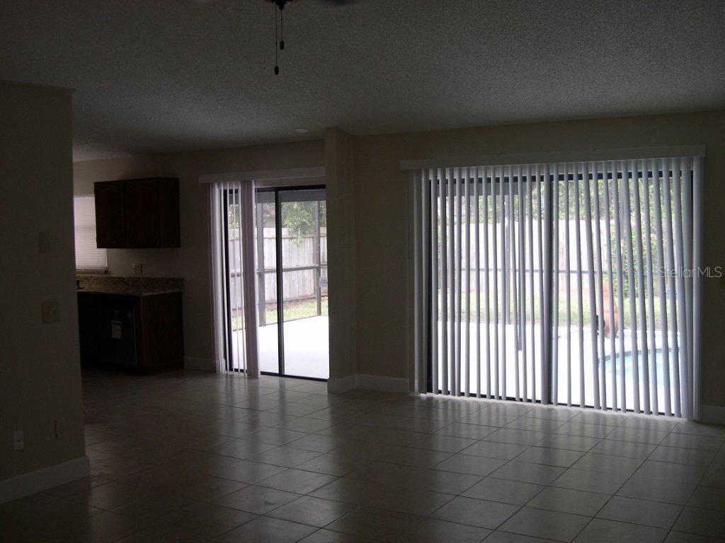 1437 East Amanda Road Kissimmee, FL 34744 - Photo 4 of 12 a view of an empty room with a window and wooden floor