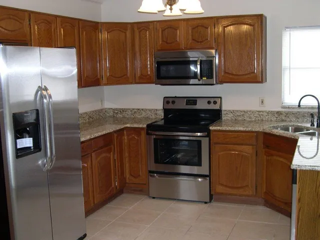 a kitchen with stainless steel appliances granite countertop a stove microwave and refrigerator
