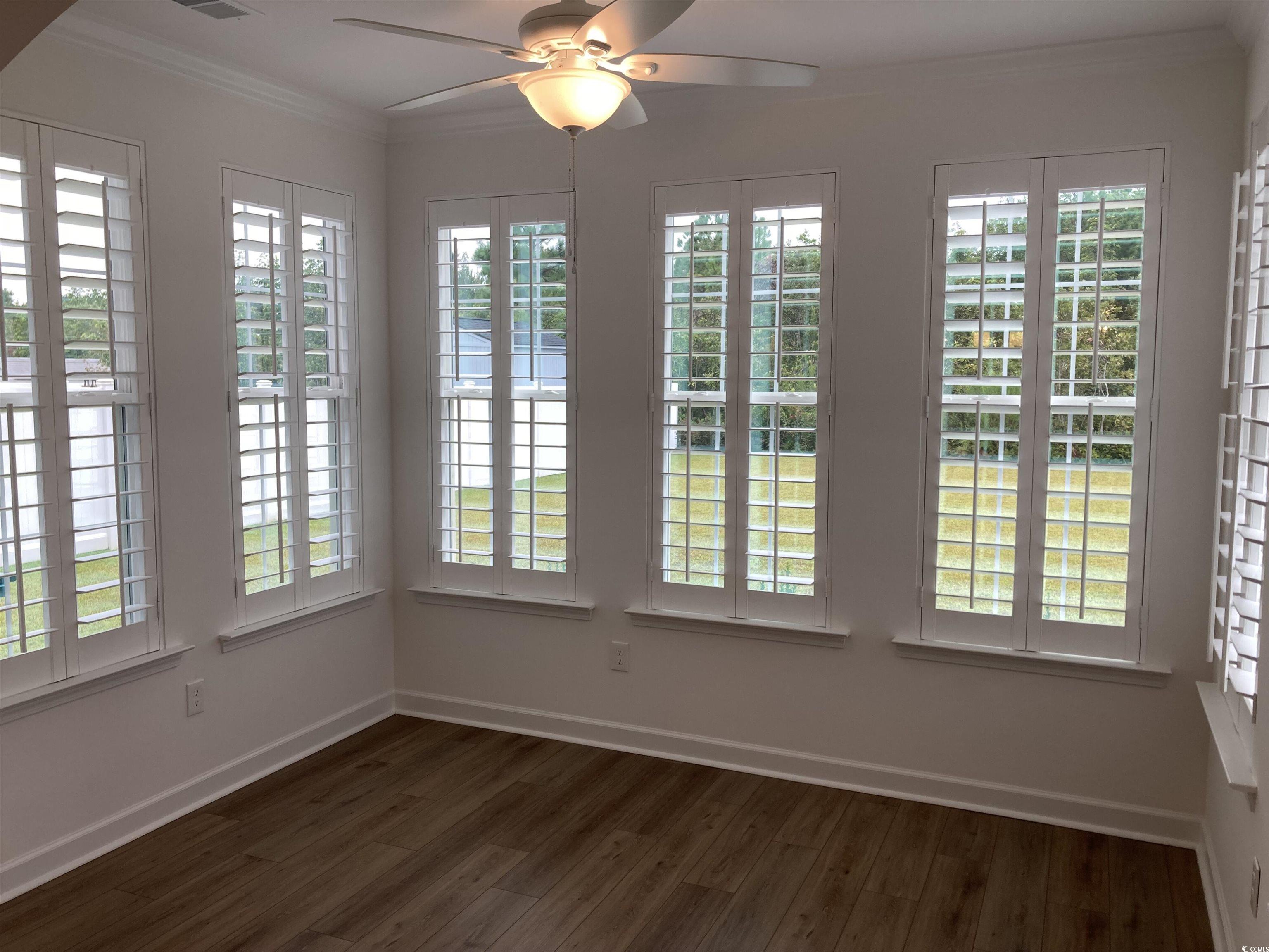 736 Enchantment Loop Myrtle Beach, SC 29588 - Photo 25 of 39 Unfurnished dining area with ornamental molding, healthy amount of natural light, dark wood finished floors, and ceiling fan