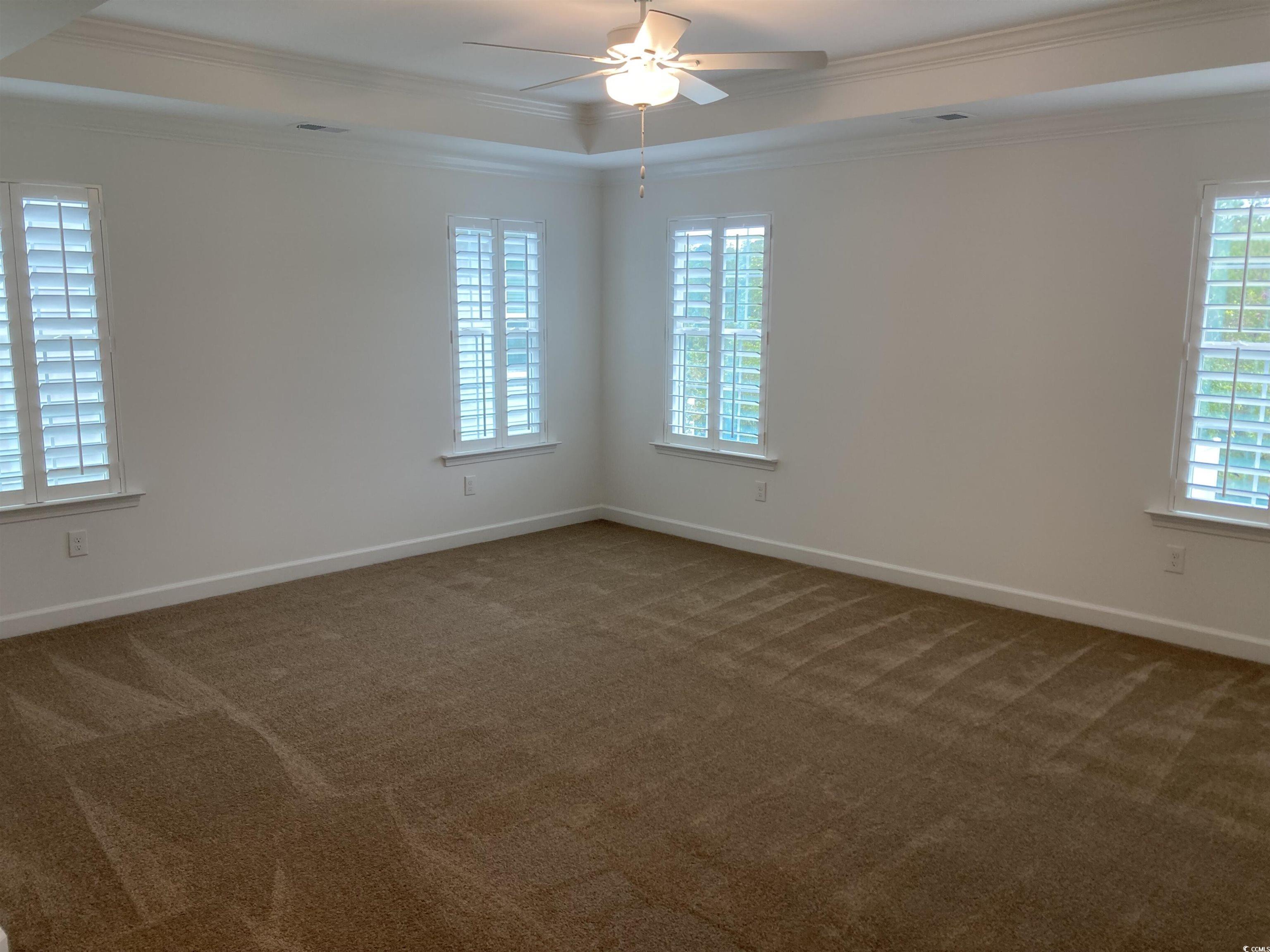 736 Enchantment Loop Myrtle Beach, SC 29588 - Photo 33 of 39 Carpeted empty room featuring crown molding, ceiling fan, and a raised ceiling