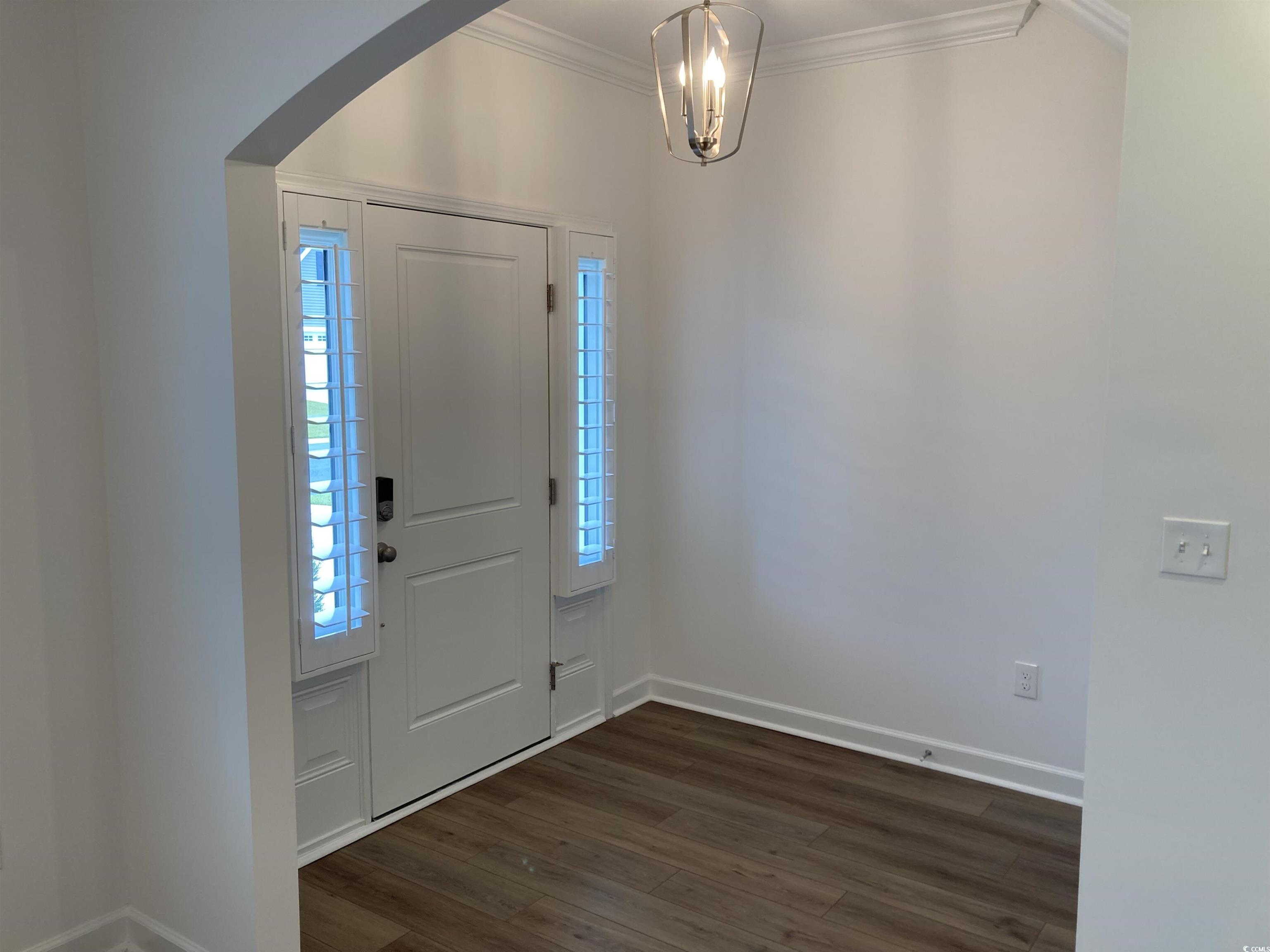736 Enchantment Loop Myrtle Beach, SC 29588 - Photo 7 of 39 Foyer with dark wood-style floors, arched walkways, crown molding, and a chandelier