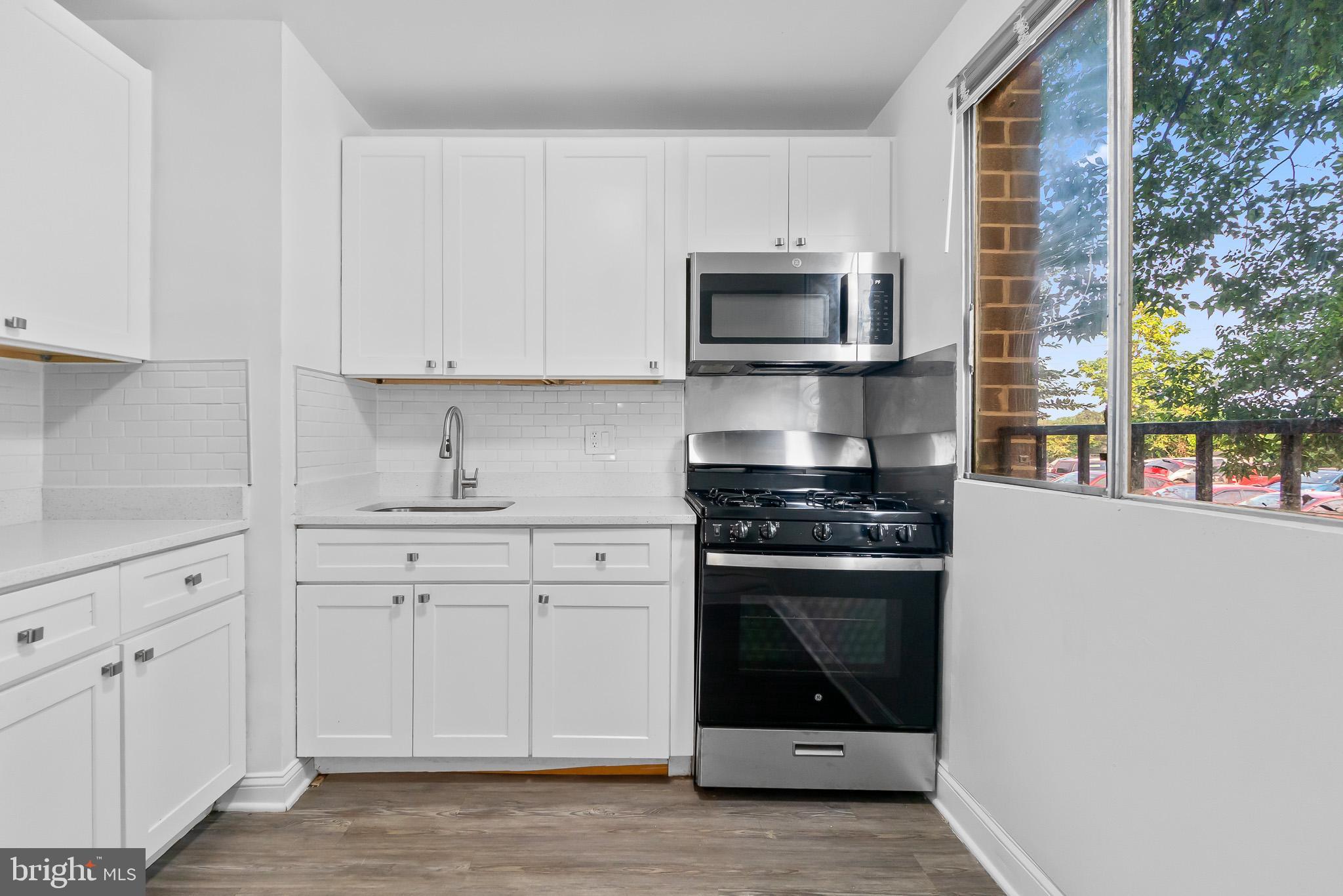 7975 Riggs Road, Unit 4 Hyattsville, MD 20783 - Photo 12 of 22 a kitchen with white cabinets and stainless steel appliances