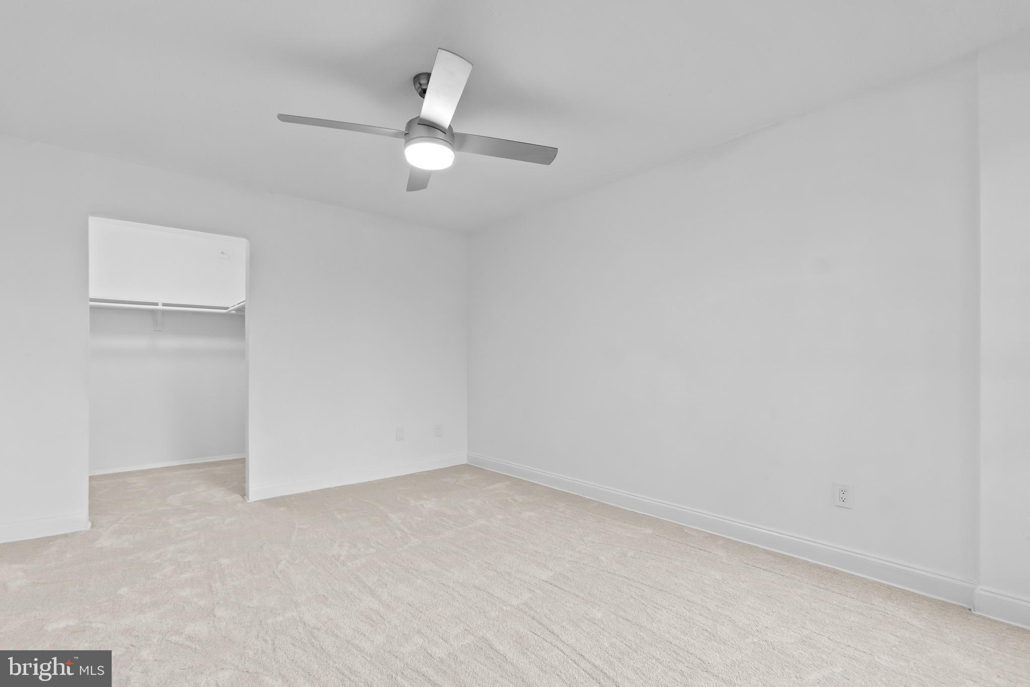 7975 Riggs Road, Unit 4 Hyattsville, MD 20783 - Photo 17 of 22 an empty room with a chandelier fan and windows