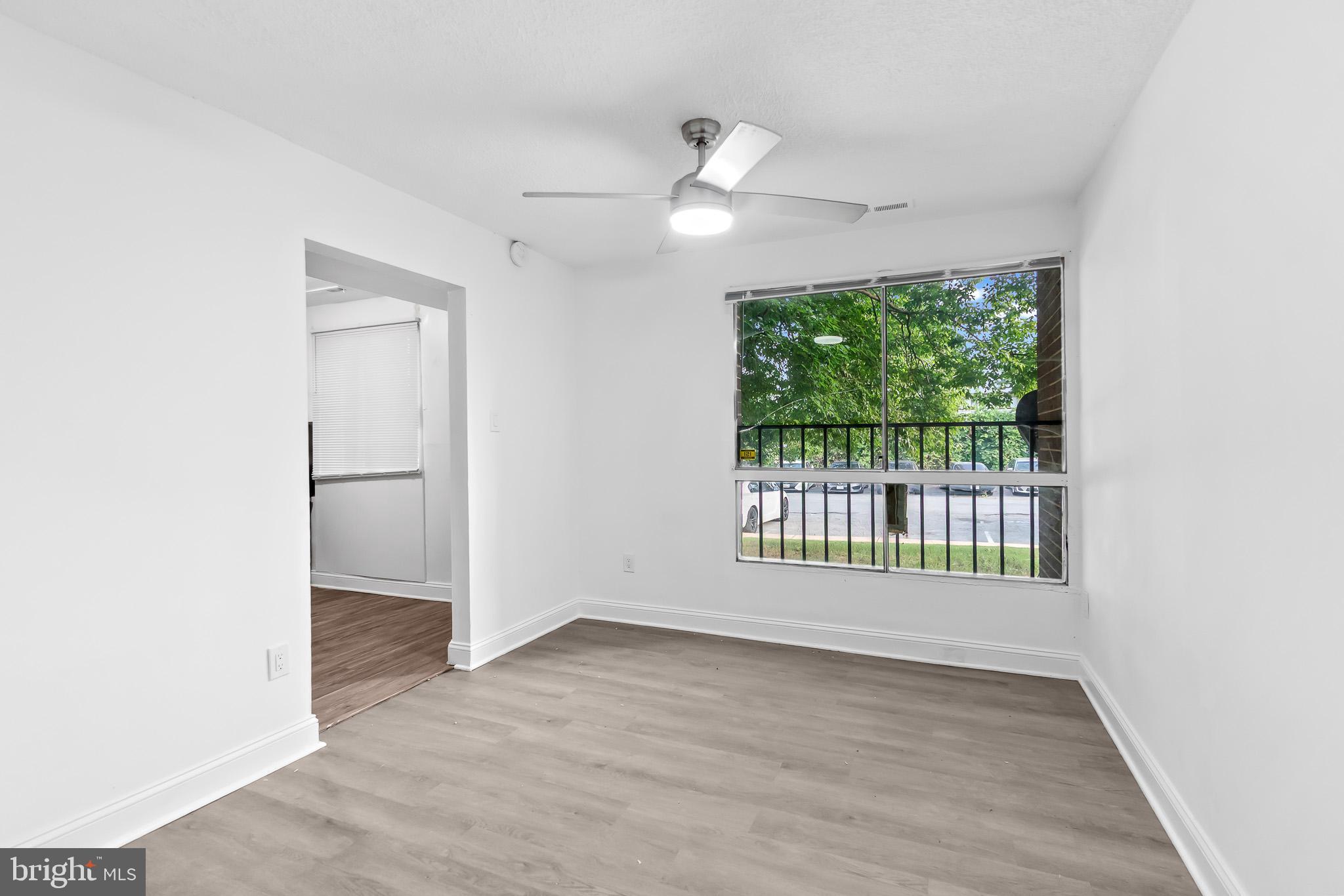 7975 Riggs Road, Unit 4 Hyattsville, MD 20783 - Photo 8 of 22 an empty room with wooden floor and windows