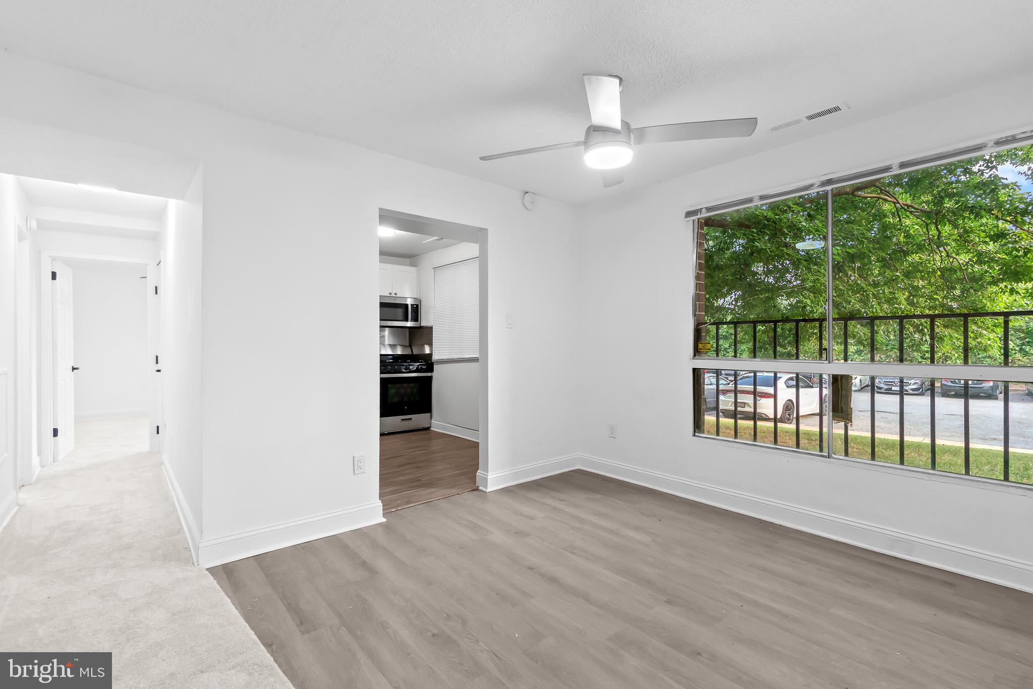 7975 Riggs Road, Unit 4 Hyattsville, MD 20783 - Photo 10 of 22 an empty room with wooden floor fan and windows
