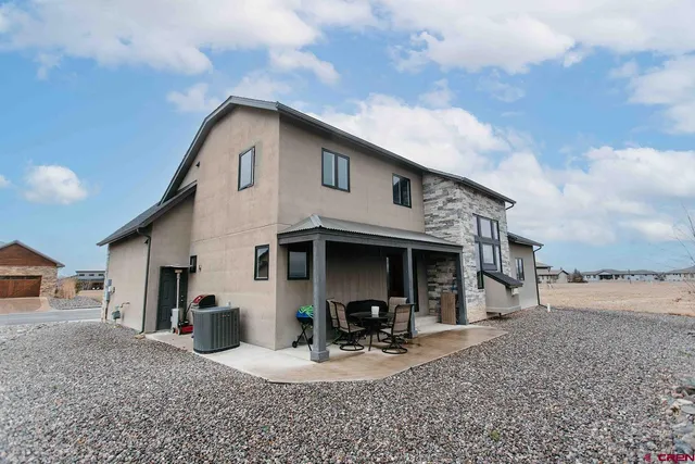 a view of a house with backyard and sitting area