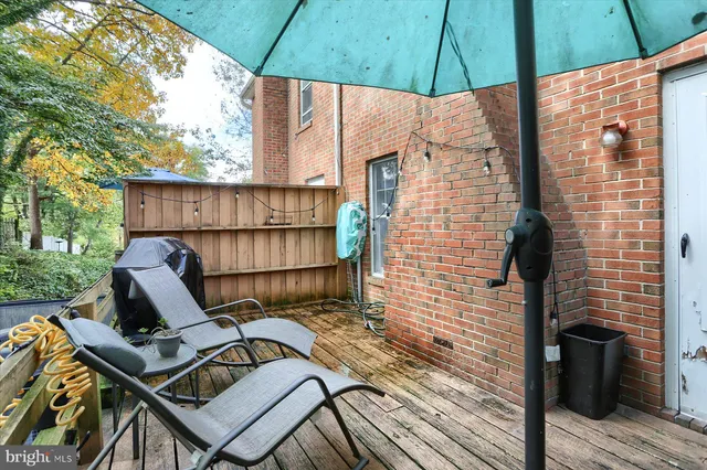 a view of a balcony with chairs and wooden fence
