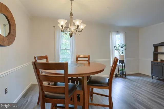 a view of a dining room with furniture a chandelier and wooden floor