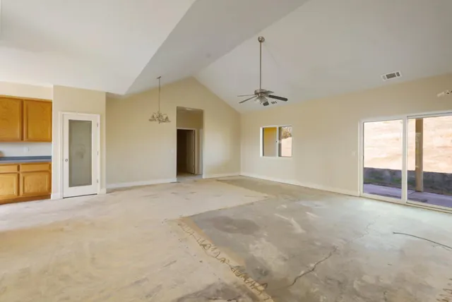 an empty room with a window and a fan