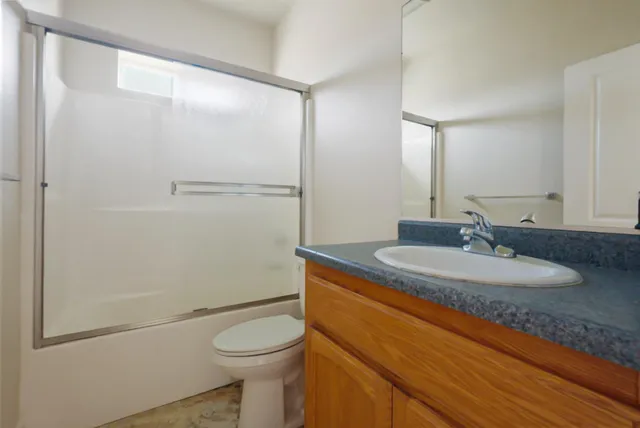 a view of a room with a ceiling fan window and a kitchen view