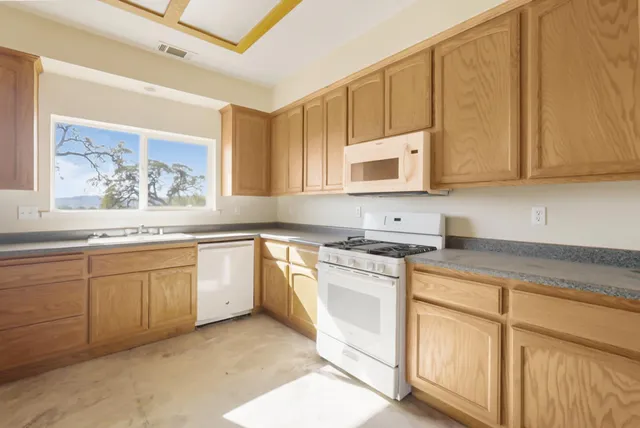 a bathroom with a granite countertop sink mirror and toilet