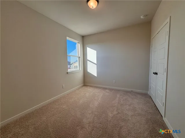 an empty room with windows and closet