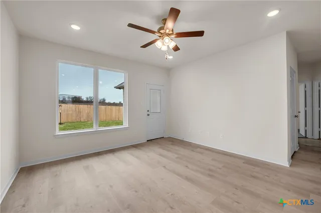 an empty room with fan and a ceiling fan