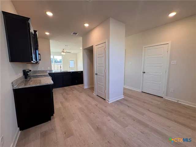 a open kitchen with a sink and a refrigerator