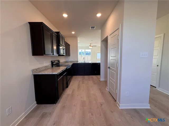 a kitchen with stainless steel appliances granite countertop a refrigerator and a sink