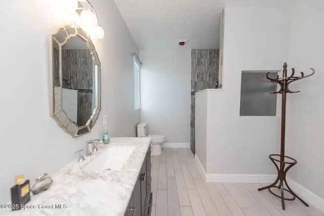 a bedroom with a bed a dresser and a chandelier