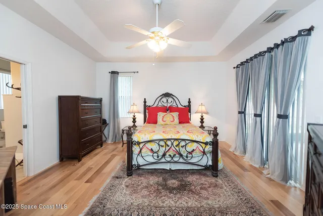 a dining room with wooden floor a chandelier a wooden table and chairs