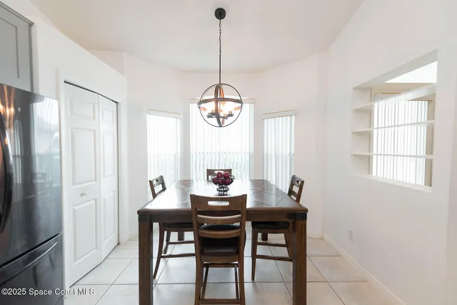 a dining room with furniture a chandelier and wooden floor