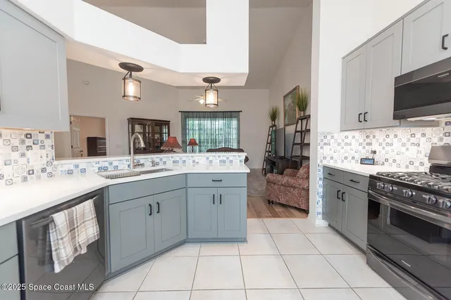 a kitchen with stainless steel appliances a sink stove and cabinets