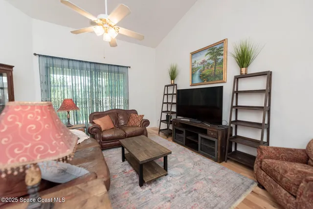 a living room with furniture a flat screen tv and a window