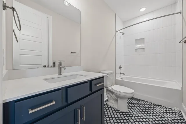 a bathroom with a sink a toilet a mirror and shower