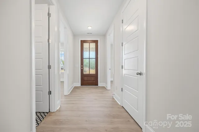 a view of a hallway with wooden floor and closet
