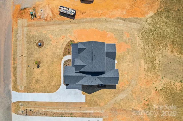 an aerial view of a house with swimming pool and large trees