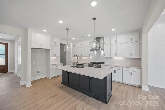 a large kitchen with stainless steel appliances granite countertop a large counter top a sink a refrigerator and a granite counter tops