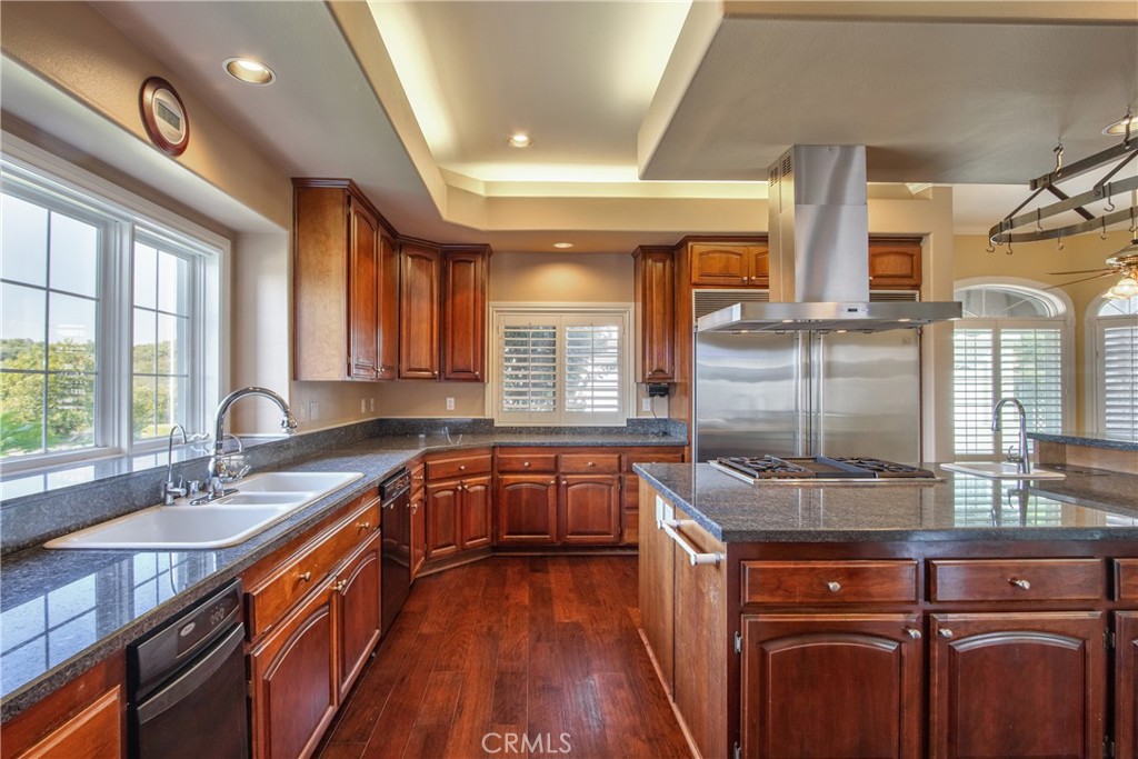 46856 El Prado Road Temecula, CA 92590 - Photo 23 of 75 a kitchen with stainless steel appliances granite countertop a sink a stove and a wooden floors
