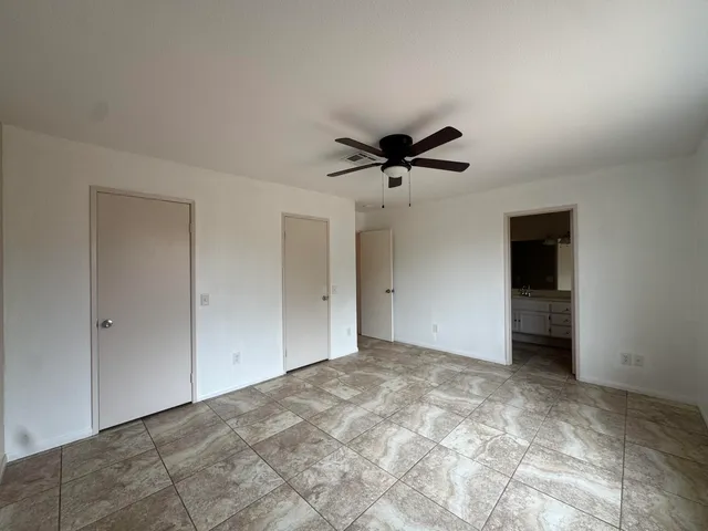 a view of a big room with a ceiling fan and a bathroom