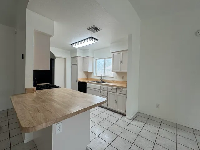 a kitchen with a sink a stove cabinets and utility room