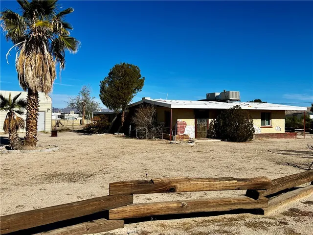 a view of a house with a yard and snow in the background