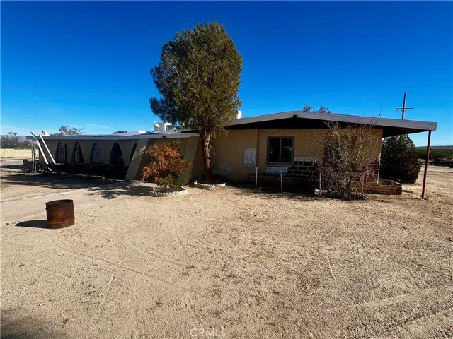 a view of a backyard of a house with cars parked and a fire pit