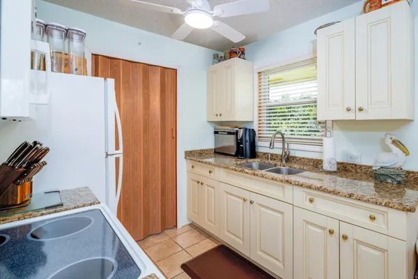 a kitchen with stainless steel appliances a stove a sink and white cabinets