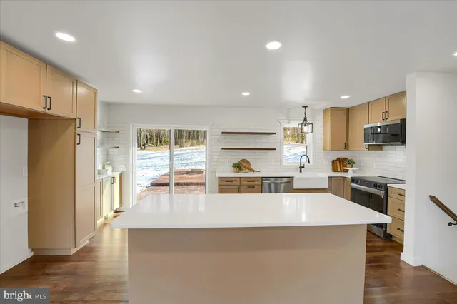 a kitchen with stainless steel appliances a refrigerator and a stove top oven
