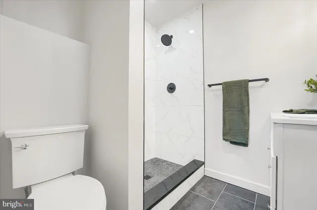 a bathroom with a toilet and a shower