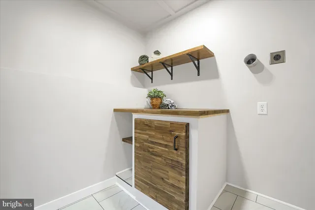 a view of an empty room with wooden floor and a potted plant