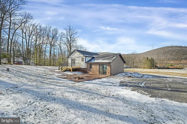 a backyard of a house with large trees and wooden fence