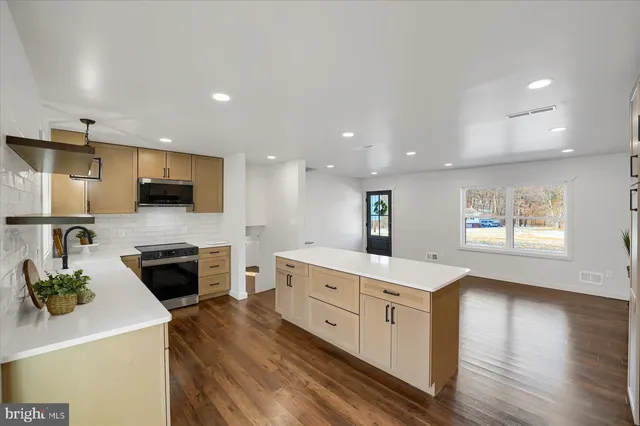 a kitchen with stainless steel appliances a stove sink and microwave