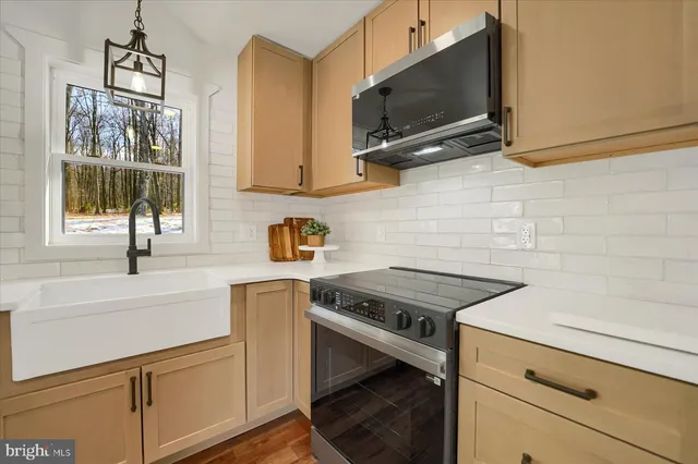 a kitchen with stainless steel appliances a stove microwave and sink