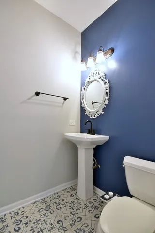 a bathroom with a sink a toilet and mirror