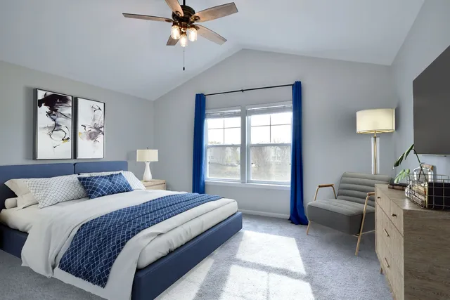 a spacious bedroom with a bed a couch and a window