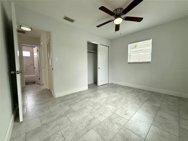 a view of an empty room and a ceiling fan